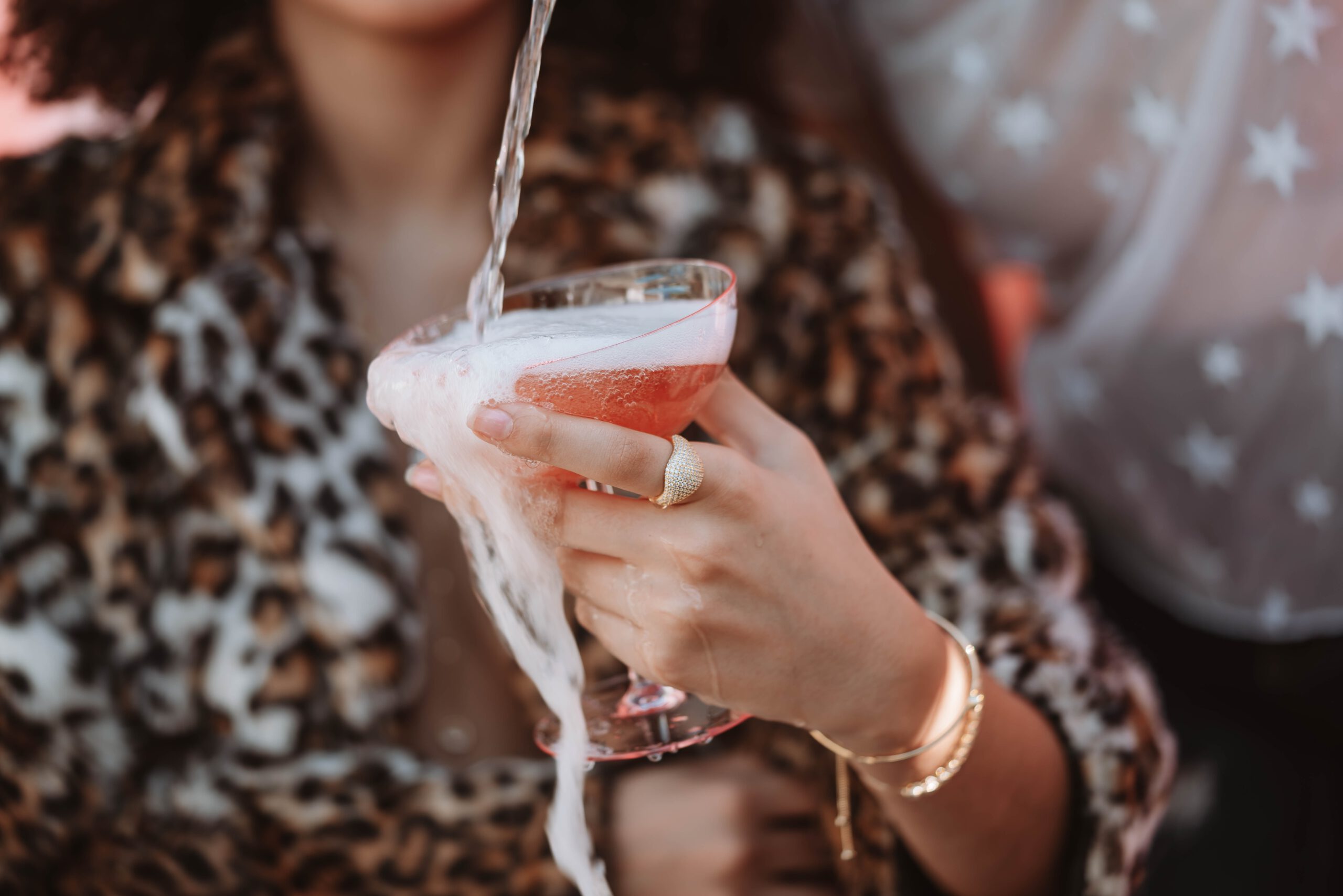 Kobieta w bluzce w panterkę trzymająca w ręce drinka